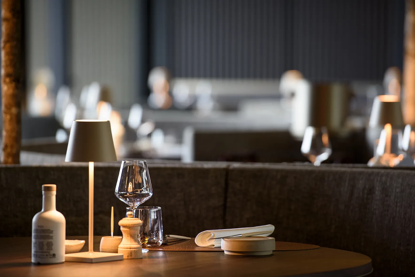 Table dressée élégamment avec verres et lampe.